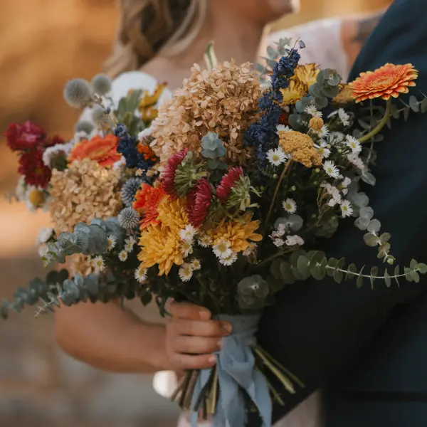 Up close of a bridal bouquet filled with harvest hues by Wildly Native Flower Farm