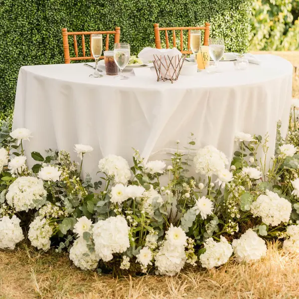 Summer white florals surrounding a sweetheart table