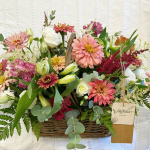 Flower basket arrangement in pinks, whites, and reds.