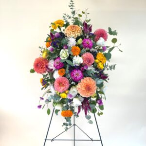 Brightly colored florals on a funeral easel stand.
