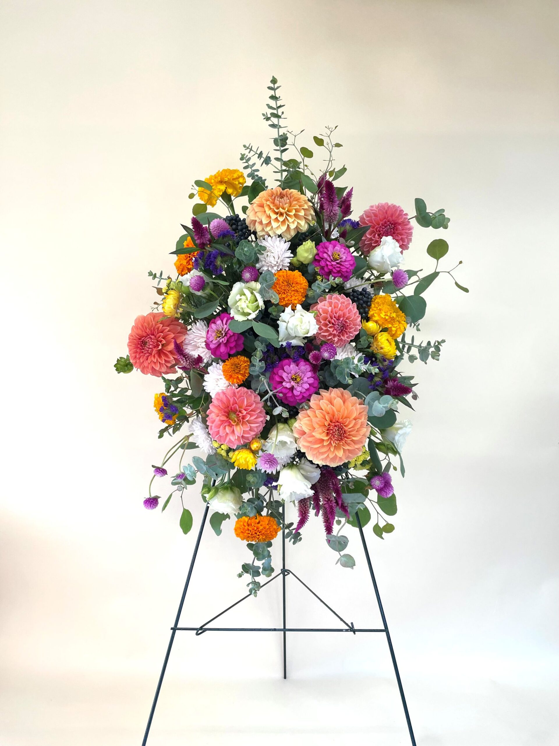 Brightly colored florals on a funeral easel stand.