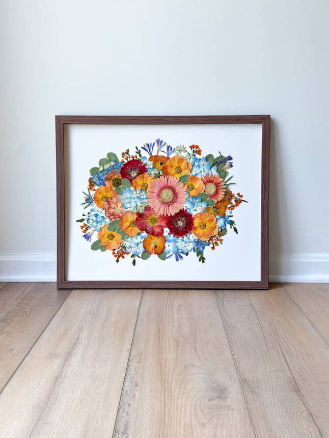 Framed art full of pressed flowers from a colorful spring wedding bouquet.