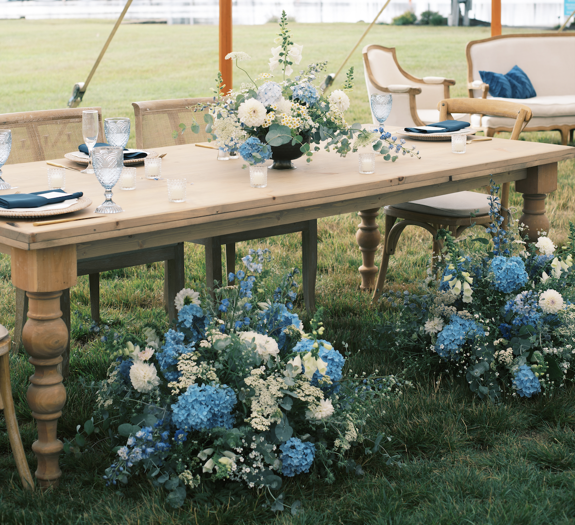 blue and white sweetheart table wedding Blue and white flowers at wedding on sweetheart table in tent