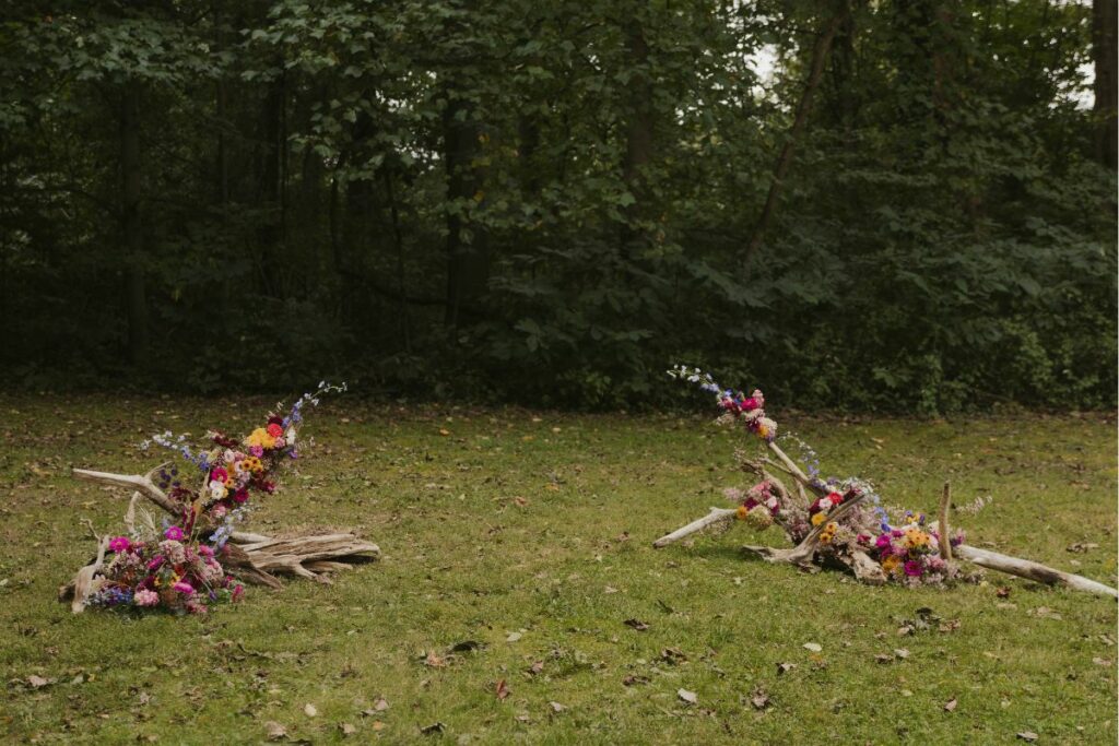 ground arch with driftwood and colorful flowers