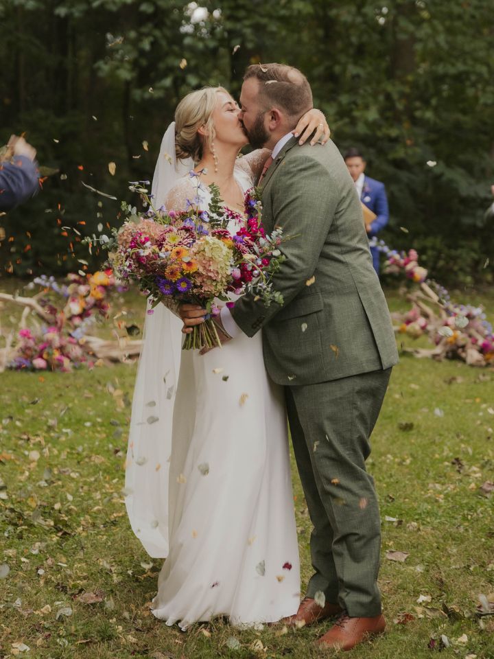 bride and groom with petals in the air