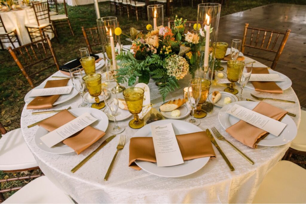 taper candles on table with fall autumn colors in compote