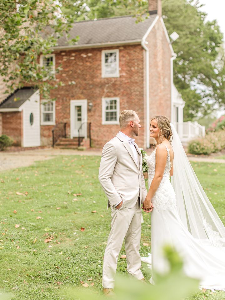 bride and groom in front of the venue house at worsaell manor