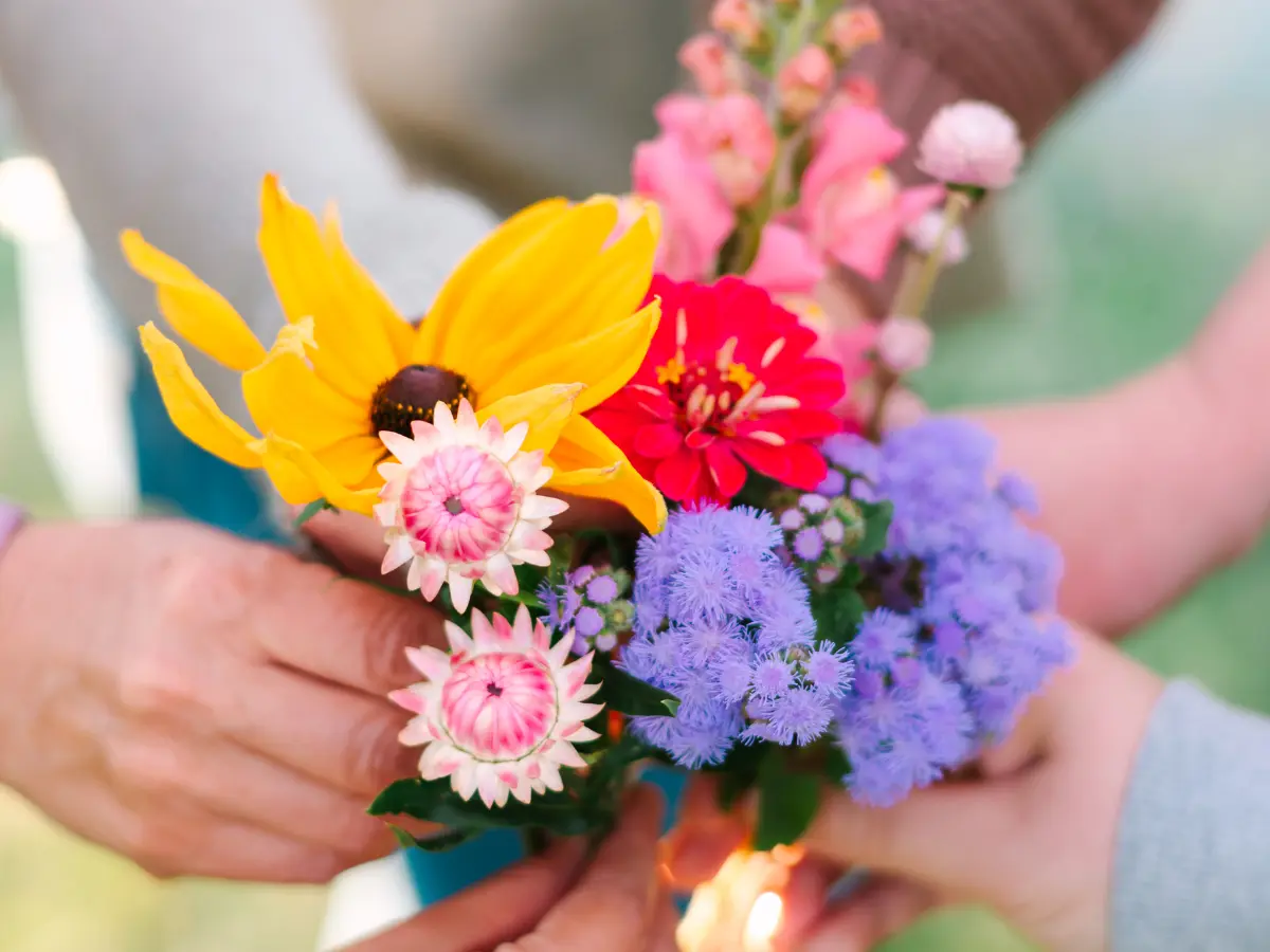 Hands in a circle holding flowers cut from the fields at Wildly Native Flower Farm