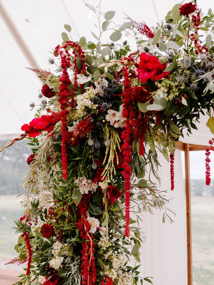 Close up of chuppah flowers in fall jewel tones.