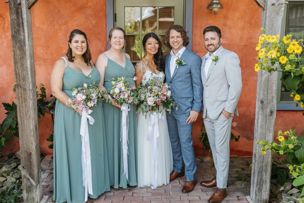 Bride and Groom pose with wedding party, holding their DIY wedding flowers.
