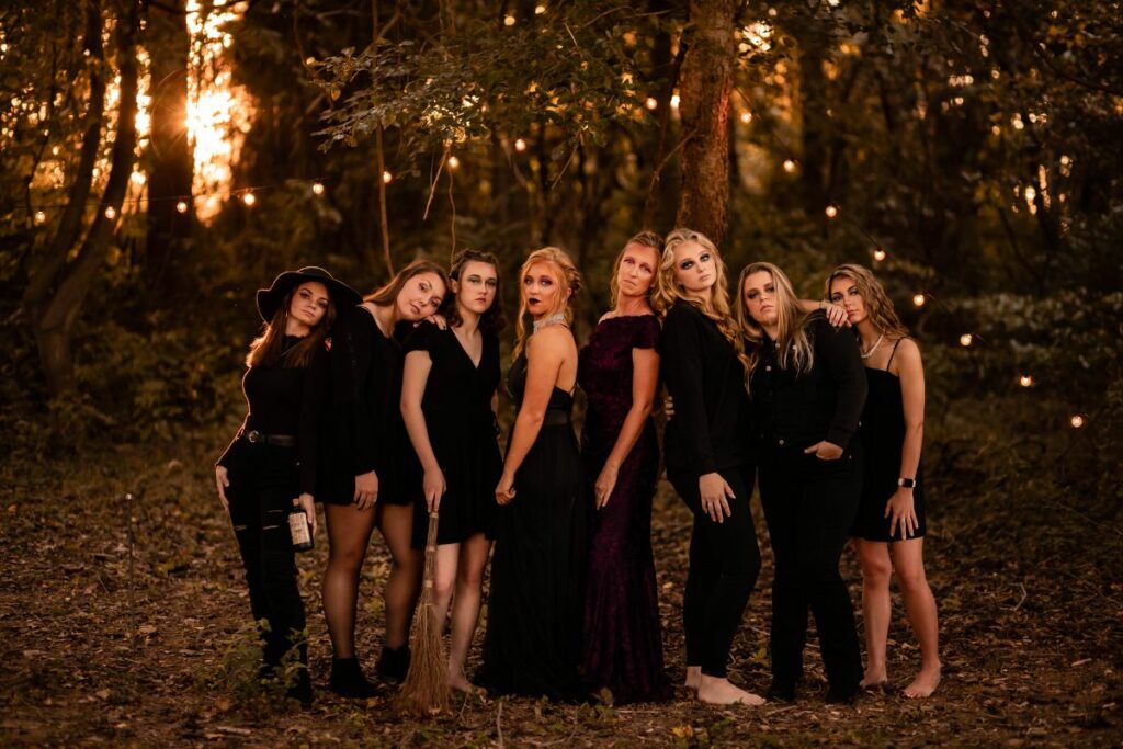 Group of women dressed as witches in the woods.