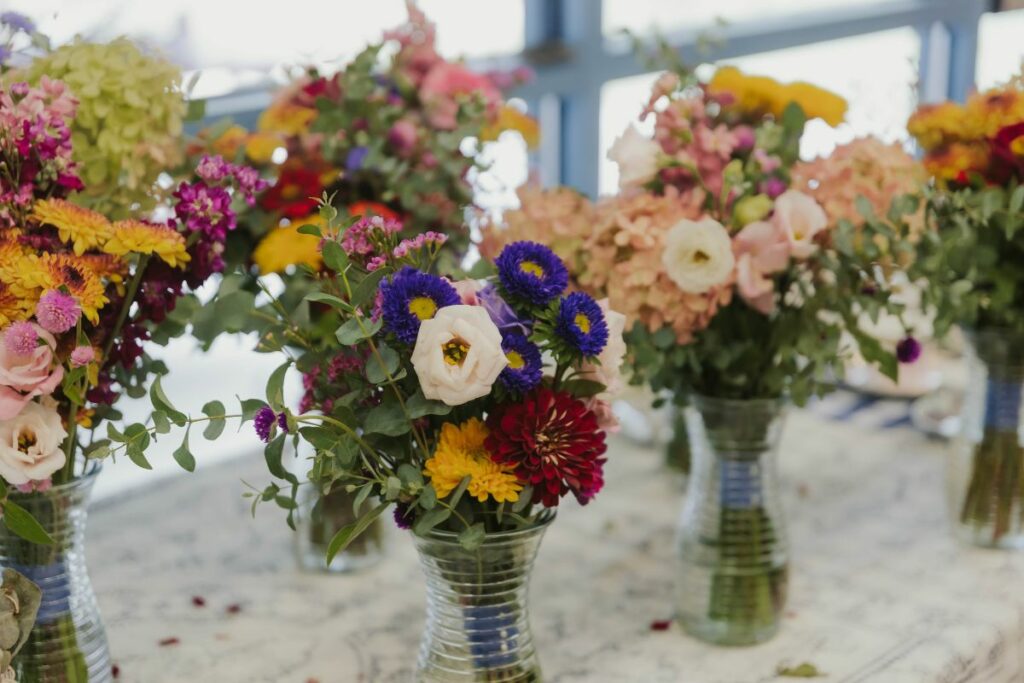 Bridesmaid vases lined up on a white tablecloth.