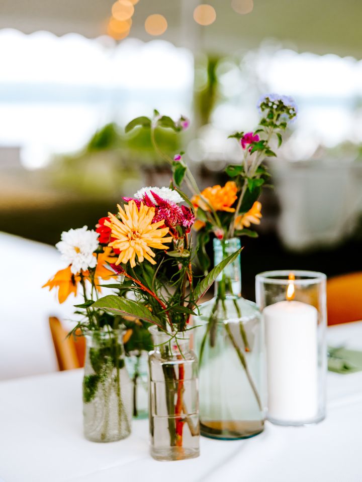Cluster of wildflower bud vases with a candle.