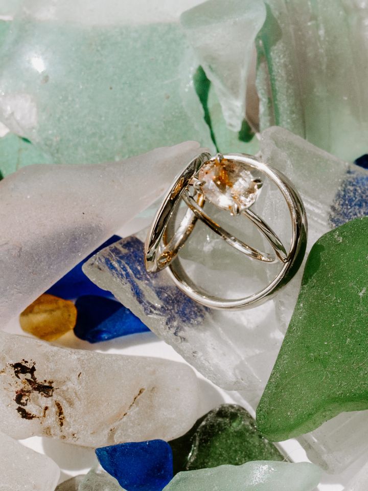 Seaglass with wedding rings on top.