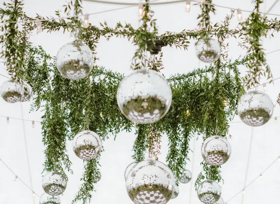 Greenery and Disco Balls Hanging from Interior of Tent