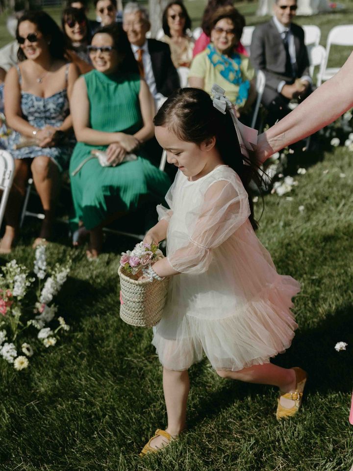 Flower girl sprinkles petals down the aisle.