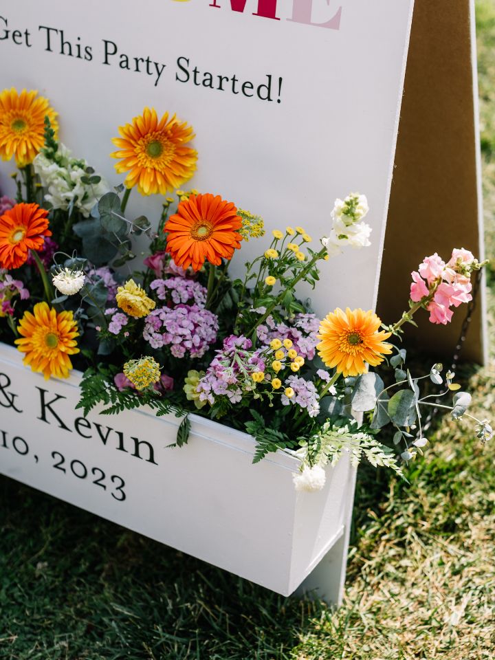 Close-up of bright florals in a welcome sign.