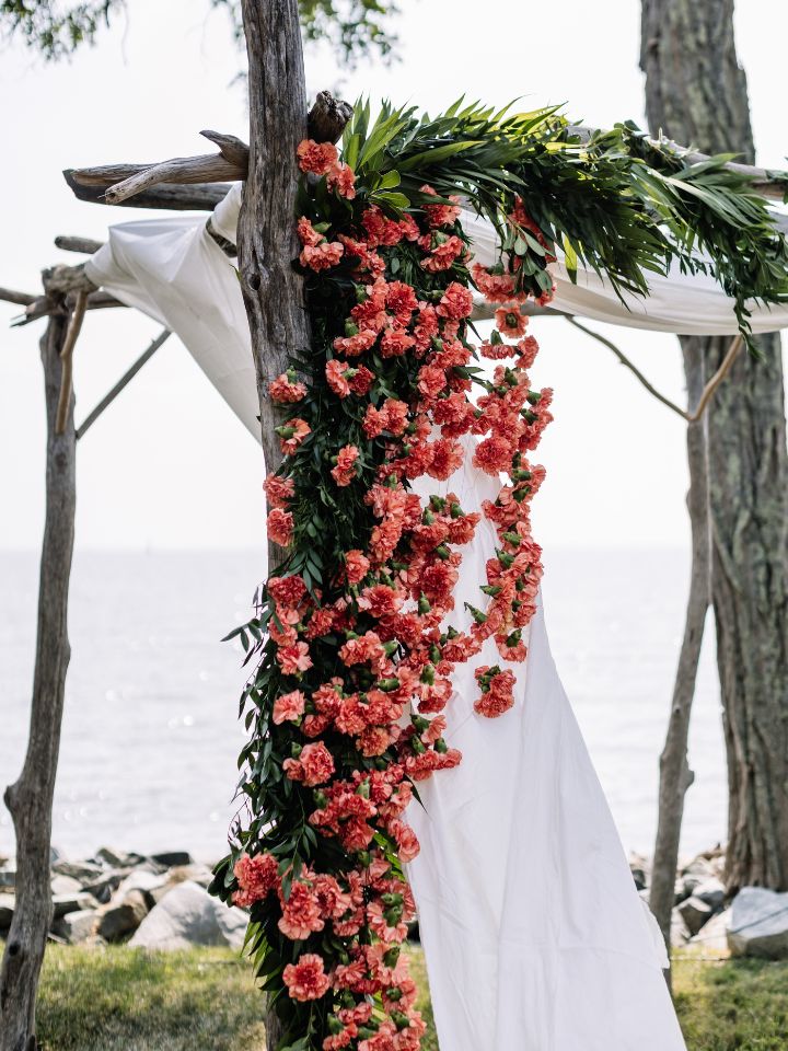 Closeup of orange and pink florals on a chuppah.