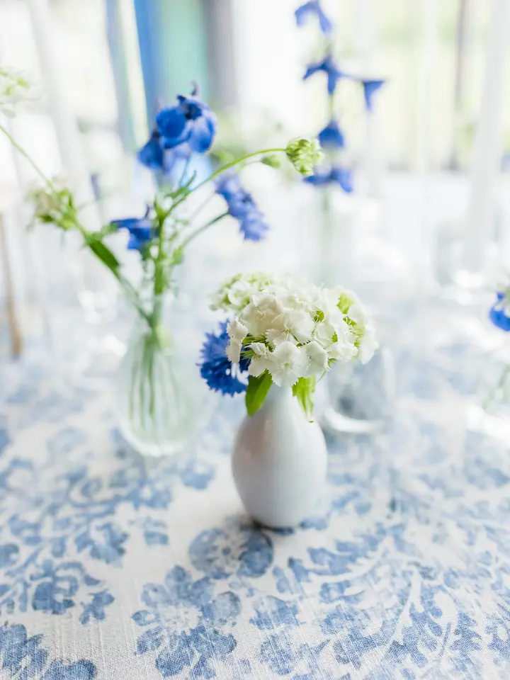 hodsonboathouse3 Up close of a cocktail table with bud vases in blue and white flowers