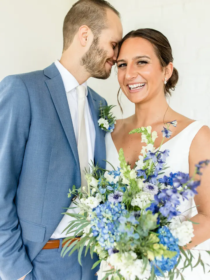 hodsonboathouse4 Bride smiling with groom holding a blue and white bouquet