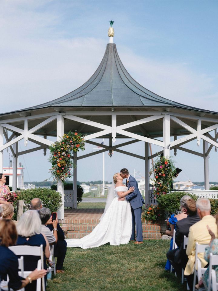Bride and Groom kiss at their wedding ceremony under the bandstand at the Chesapeake Bay Maritime Museum.