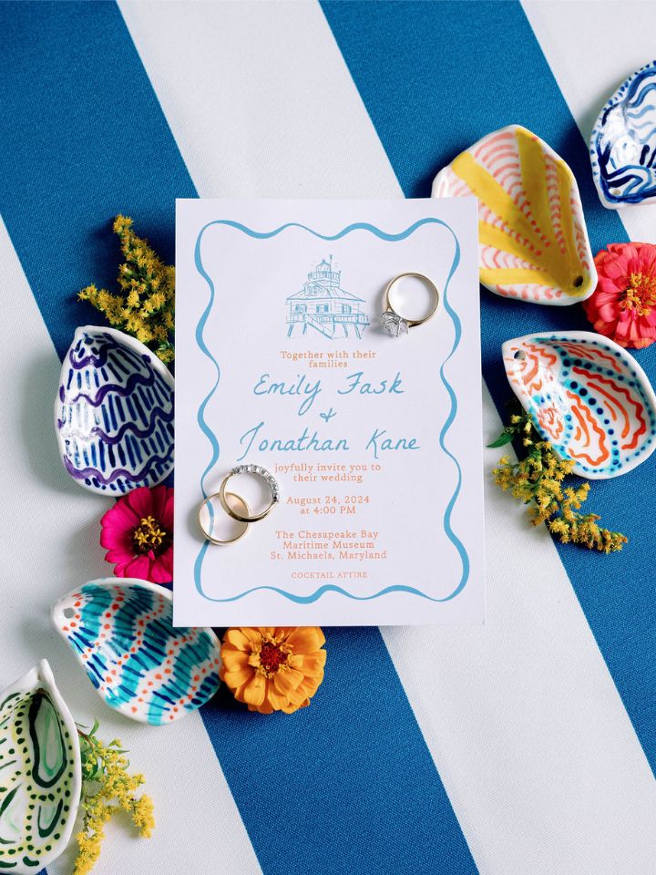 Flatlay detail photo of a wedding invitation with bright blues, pinks, and yellow.