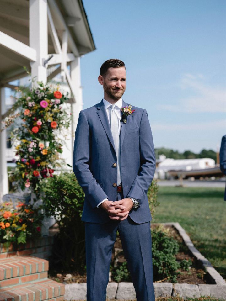 Groom stands at the wedding ceremony waiting for the processional.