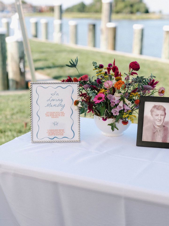 A white compote container holds bright summer florals.