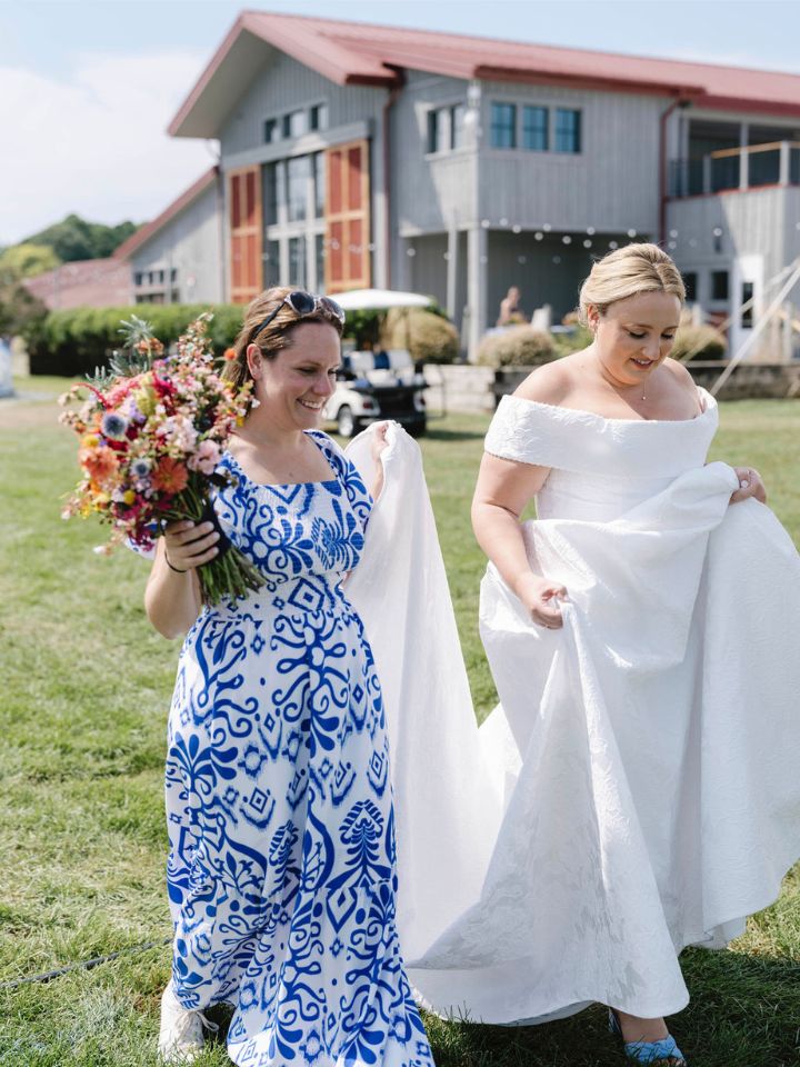 Wedding planner Sara Reynolds holds the bridal bouquet while walking the bride out for photos.