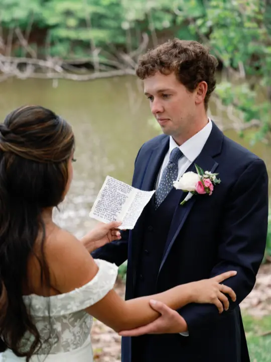 bridereadingvowsatpacahouse Bride reading her vows to a groom with a spring pastel boutonniere