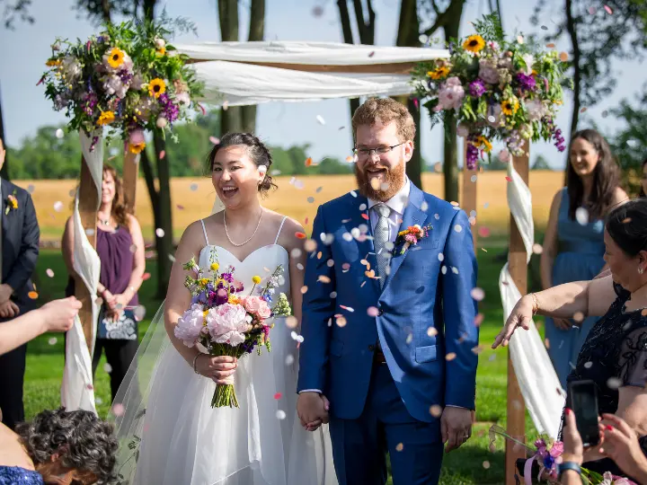 yellowpurplefloralsonchuppah Yellow and purple, and other bright flowers, on a fabric chuppah