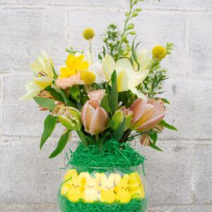 Peeps candy inside of a glass vase with Easter flower arrangement.