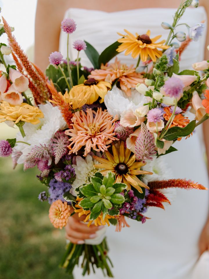 Closeup of bridal bouquet with colorful September flowers.