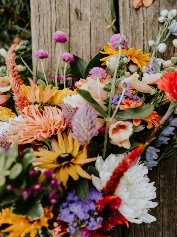 Detail of colorful fall bridal bouquet with yellows, purples, white, pinks.