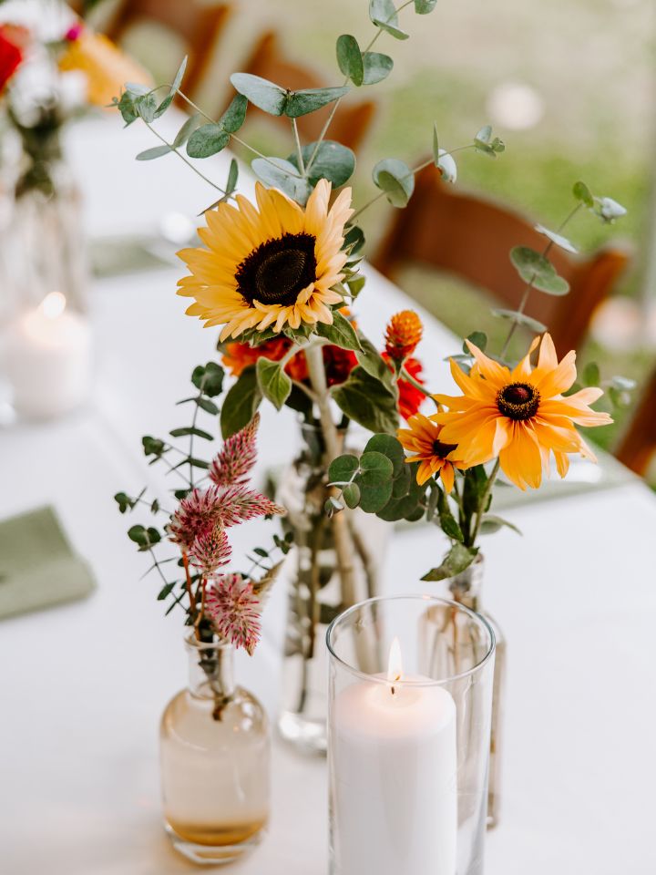 Sunflowers, black eyed susans, celosia, and eucalyptus in bud vases.