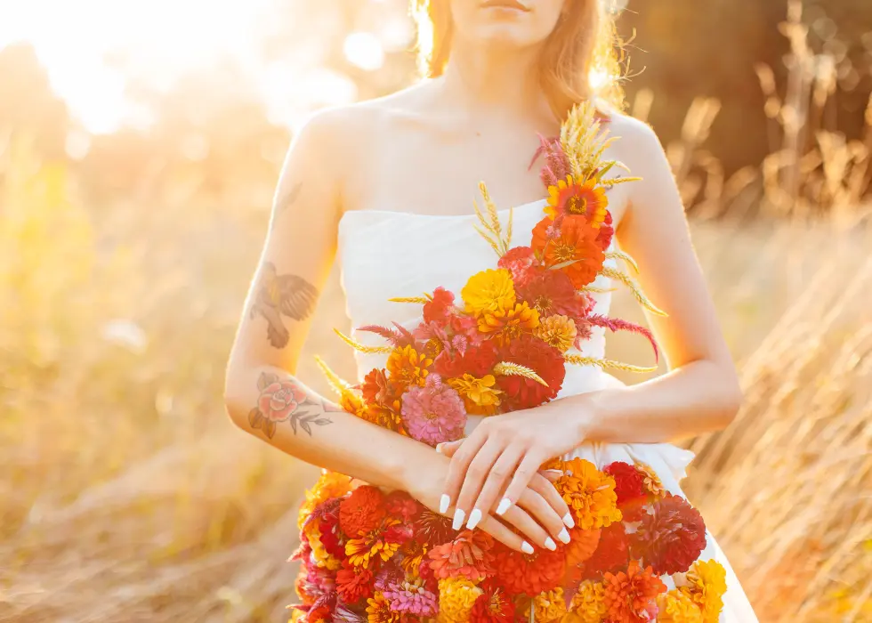 Girl wearing a dress made of flowers standing in a field