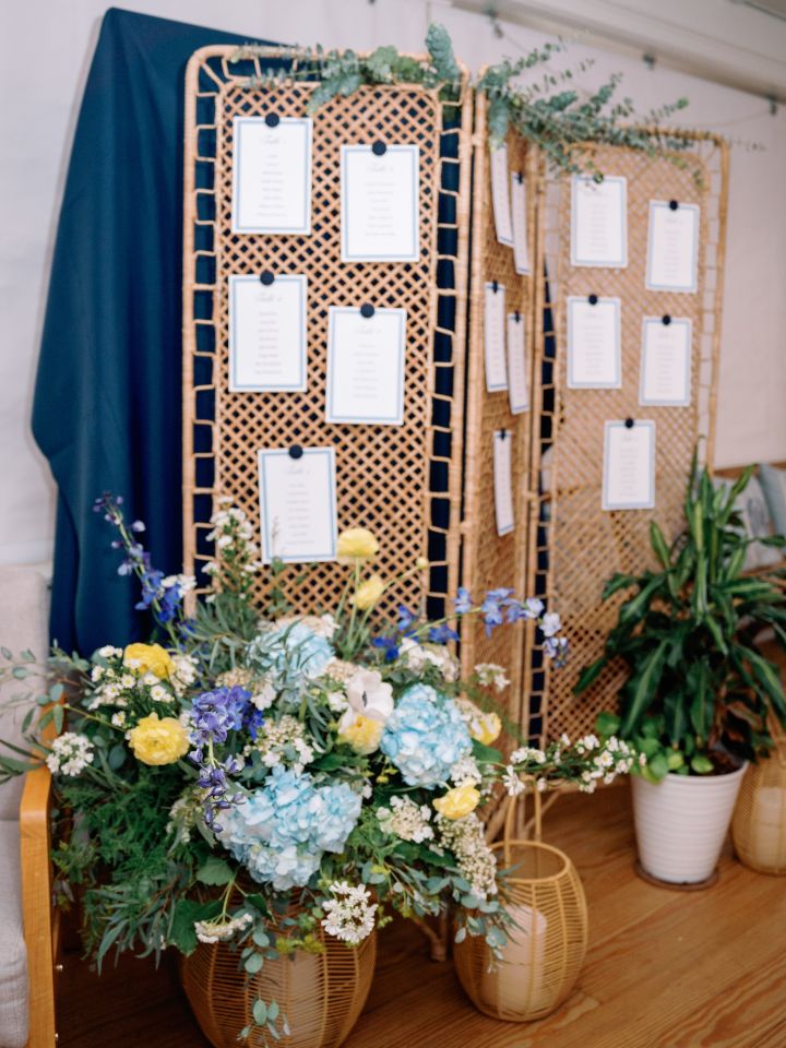Trifold cane screen with eucalyptus across the top, and large floral arrangement at base.