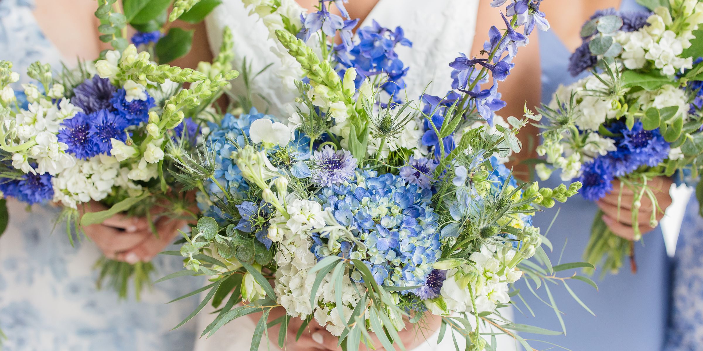 closeup of bridal and bridesmaid bouquets in spring blue and white flowers.