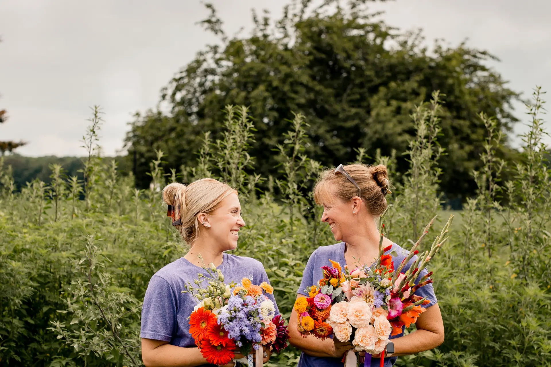 Group photo of the team behind Wildly Native Flower Farm, standing in the flower field together smiling at the camera