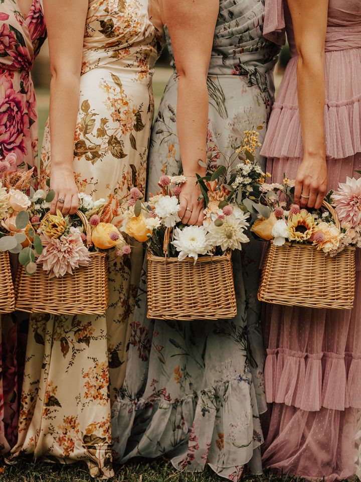 basket bridesmaids Closeup of bridesmaids in muted neutrals holding baskets with floral arrangements as bouquets.