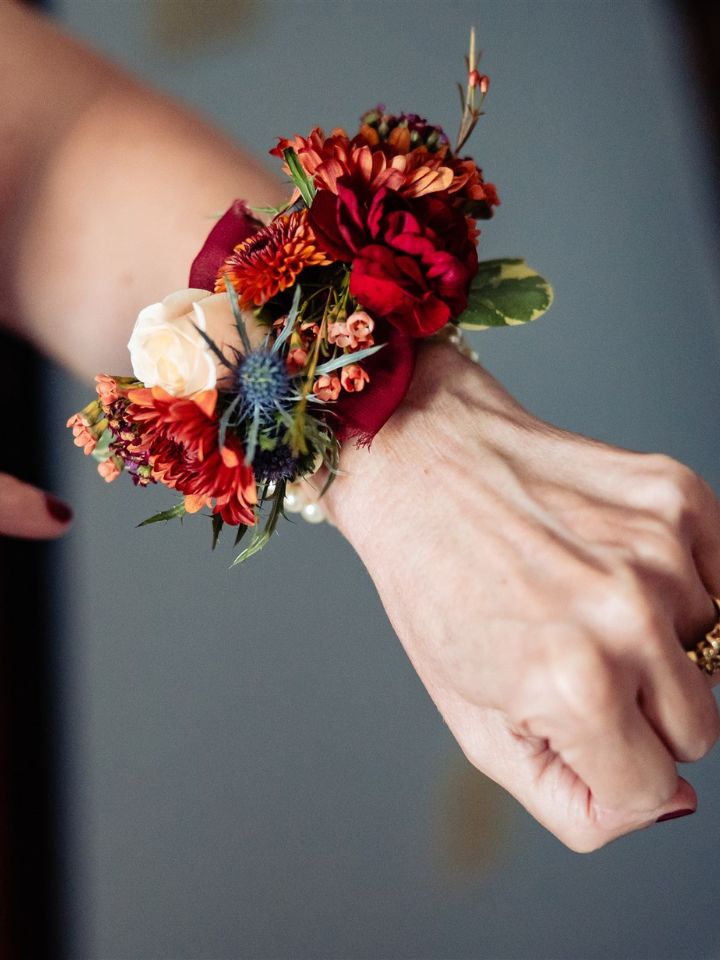 fall color wrist corsage Wrist corsage in dark reds, rust, and blue flowers.