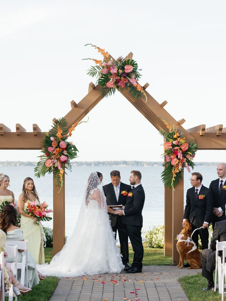 Arch at Herrington on the Bay with three large tropical floral arrangements.