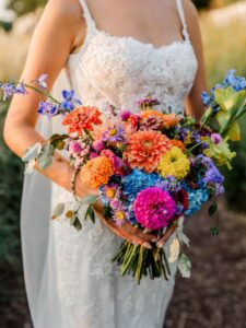 kelli classic one sided Closeup of bride holding colorful summer bouquet.