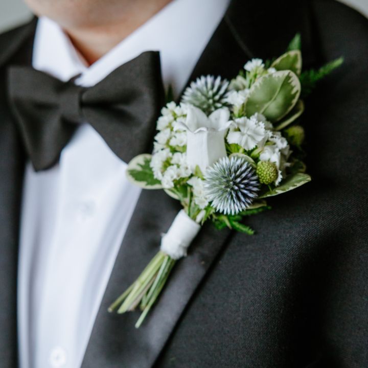 personals boutonniere sq Black tuxedo jacket with blue and white floral boutonniere.