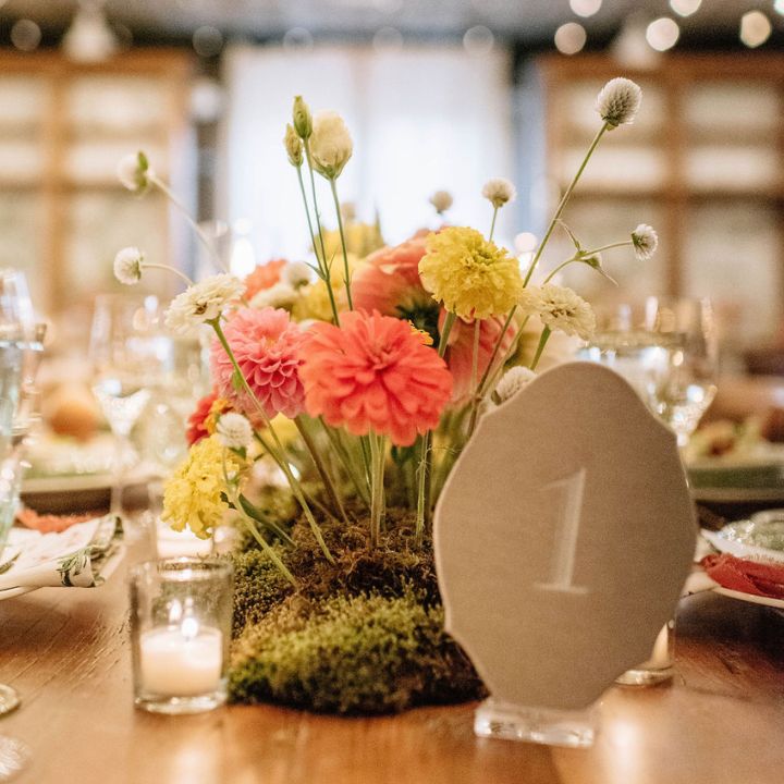 Moss arrangement with pink and yellow florals.