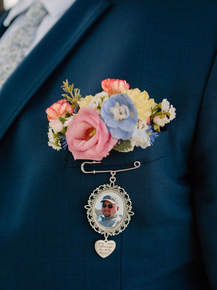 spring flower pocket square Closeup of navy blue suit jacket with spring flower pocket square, and a photo charm pinned on.