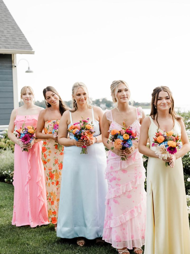 summer colors bridesmaids Bridesmaids in pastel dresses hold petite bouquets in bright summer colors.