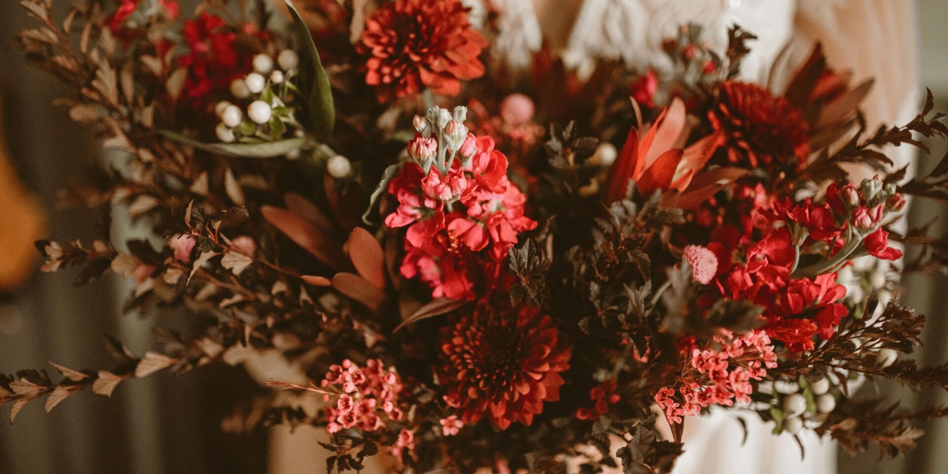 Closeup of dark and moody burgundy black wedding bouquet.