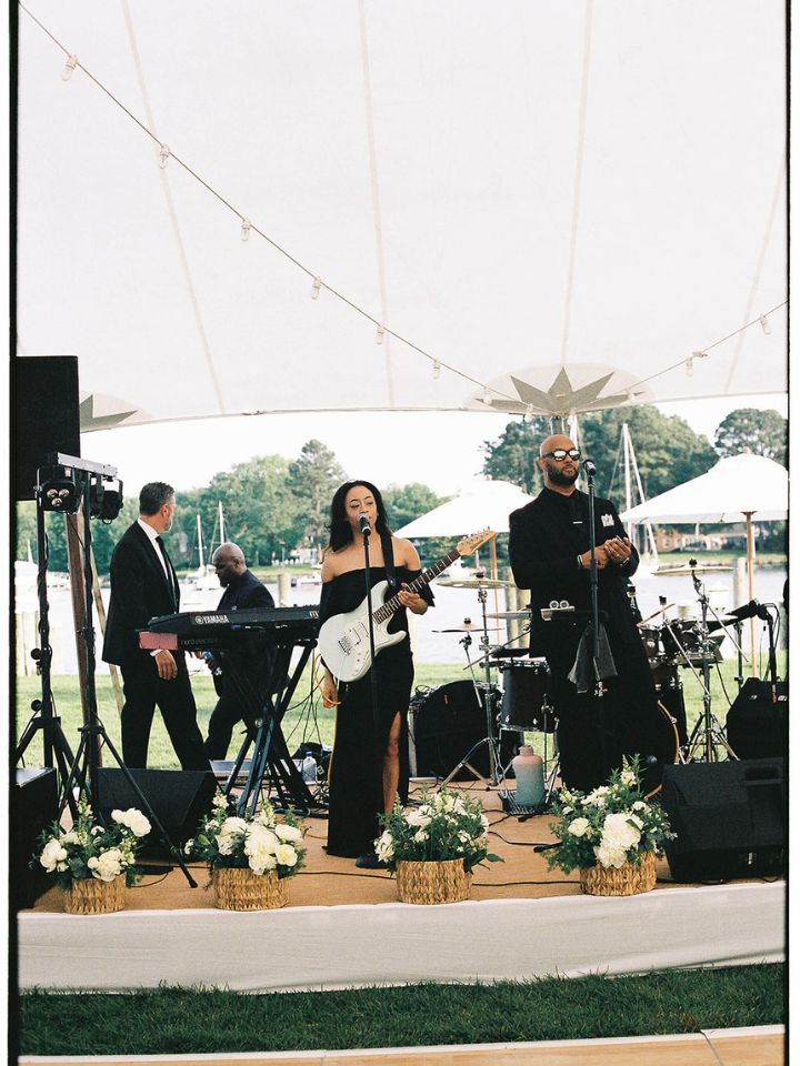 Band on stage with florals around edge of stage.