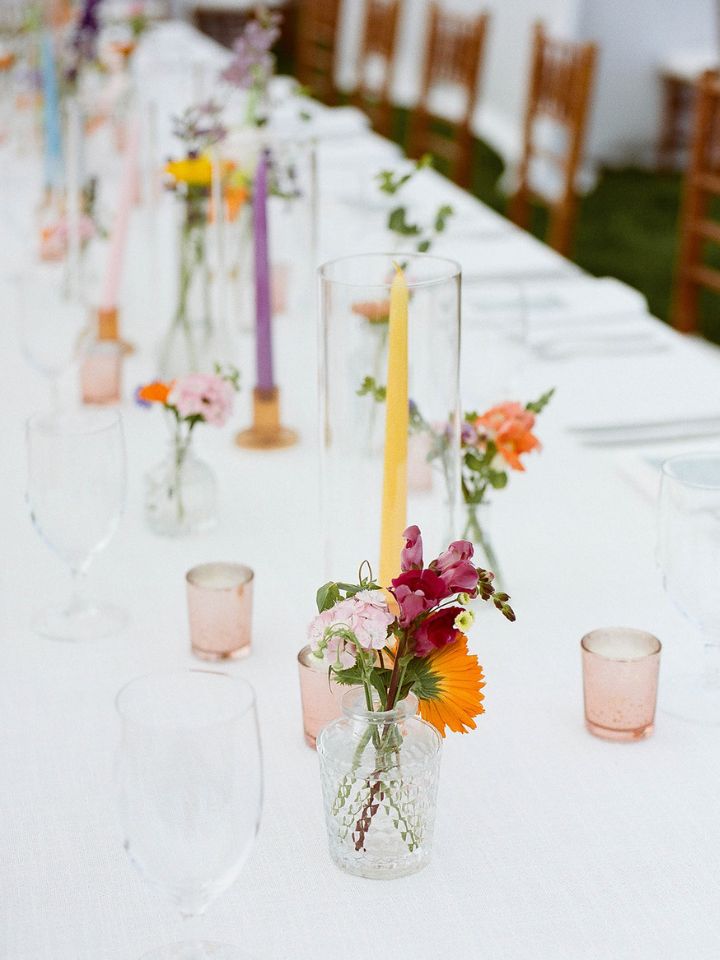 Bud vases and candles on a guest table.